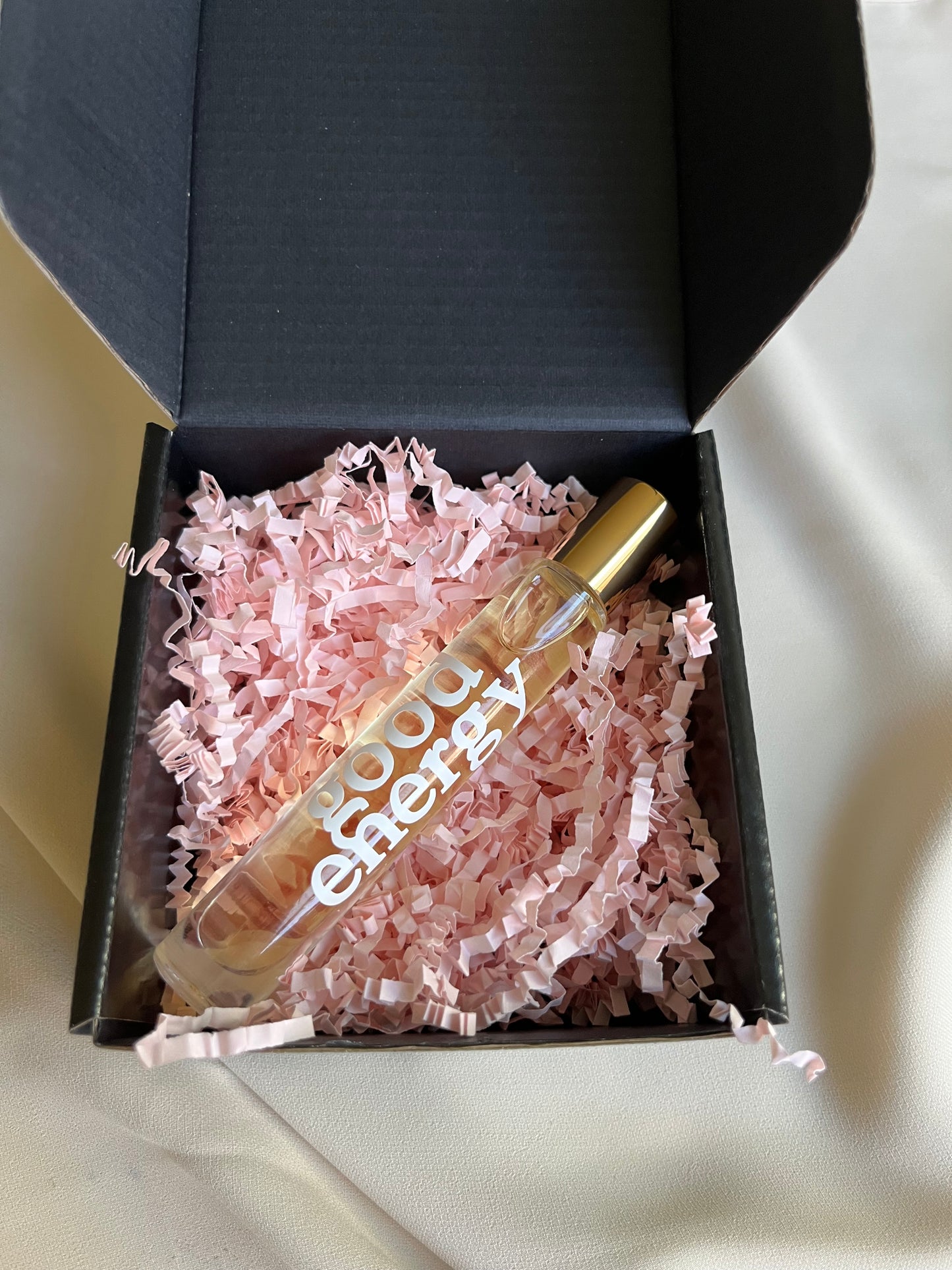 Perfume bottle with 'Chloe' branding in a black box with pink crinkle paper